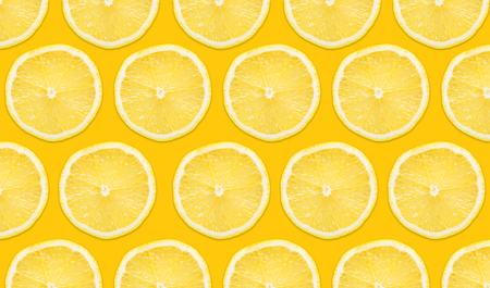 Yellow lemon slices pattern isolated on white background. Vibrant fruit background.