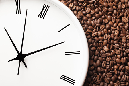 Coffee time background. White round clock with coffee seeds around.の写真素材
