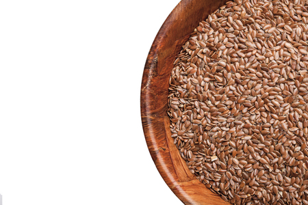 Flaxseed in wooden bowl isolated on white. Linseed food background with empty copy space for text...