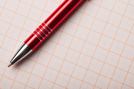 Empty copy space engineer background. Red pen isolated on grid lines graph paper.の写真素材