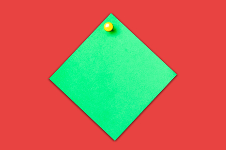 Green memo card with yellow pin. Note paper empty copy space isolated on red with shadow.の写真素材