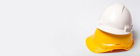 Yellow and white protection helmets isolated on white. Construction site engineer and worker with a headache horizontal background with empty copy space.の写真素材