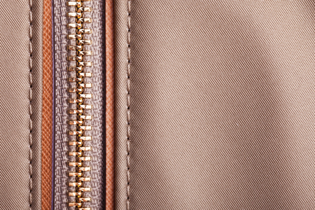 Brown metal handbag zipper closeup. Fashion fabric texture with thread sewの写真素材