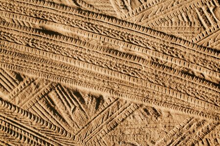 Tire mark shape lines on dry yellow sand pattern.の写真素材