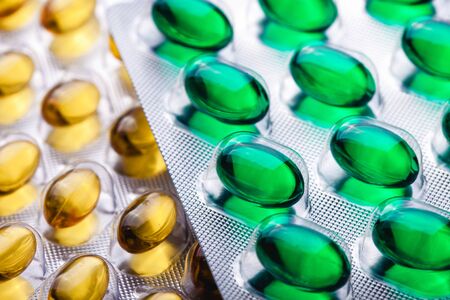 Green pill capsules medicine blister background.
