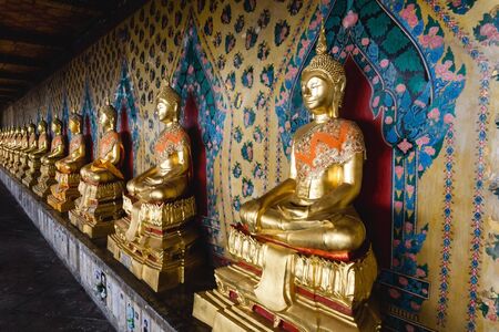 Wat Arun Temple in Bangkok. Golden Buddha statue in a row. Summer holiday in Asia.のeditorial素材