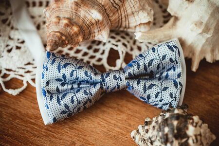 Elegant bowtie on wooden table. Wedding fashion accessories background.
