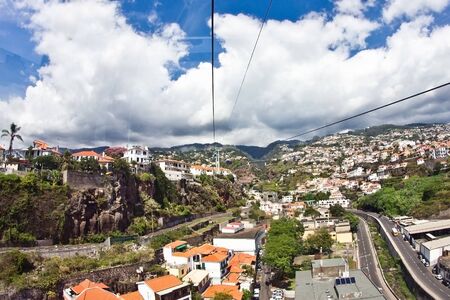 Madeira cityscape. Island of Portugal. Top view from Botanical Garden cable car. Scenic view ropeway ride over city rooftops.の写真素材