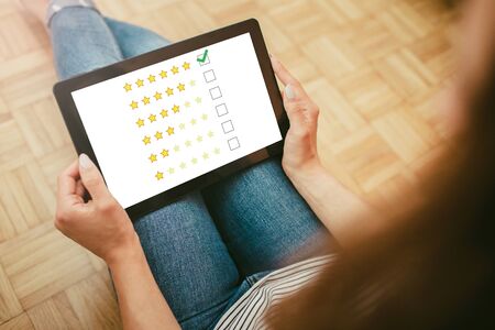 Young girl holding tablet. Internet satisfaction survey. Quality review at home. Customer rating...