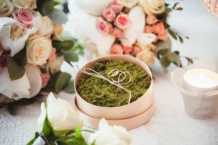 Rustic wedding love symbol. Golden wedding rings on green forest moss.の写真素材