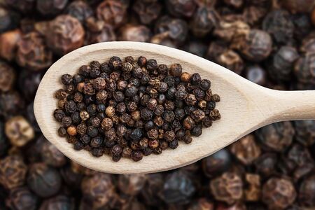 Black pepper background. Peppercorn texture. Food ingredient spices pattern. Shallow depth of field...