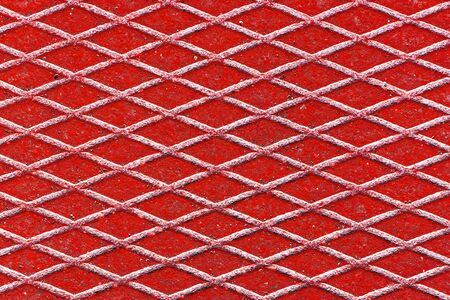 Metal grid walkway. Red grunge steel mesh texture. Heavy iron backdrop pattern. Industrial grate design background.の写真素材