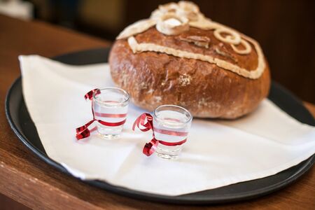 Wedding tradition in Poland. Parents welcome bride and groom with bread, vodka and salt. Decorative...