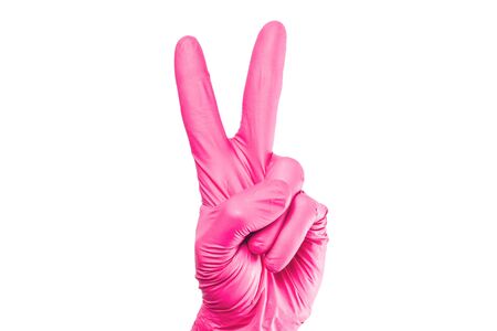 Victory sign isolated. Hand in pink latex glove. Success hand gesture. Hygiene viruses and bacteria protection. Number two count on fingers.の写真素材