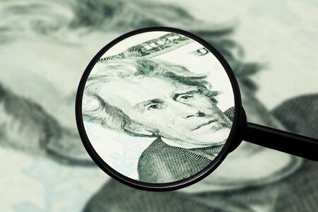 Dollar bill inspection. Magnyfing glass closeup check. Counterfeit money problem background. Twenty...