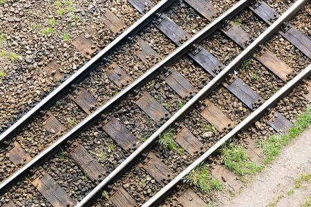 Simple railway top view background. Train track texture. Steel rail on gravel. Good and cheap way of transportation for cargo. Journey and travel symbolic view. Old railroad wooden tie.の写真素材