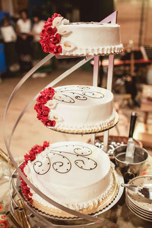 Wedding tradition in Poland. Bride and groom make the first cut of their wedding cake. Wedding reception celebration background. Sweet dessert for a couple.の写真素材