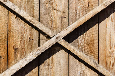 Wooden barn door. X shape wooden desks. Rustic nails vintage desk construction background....