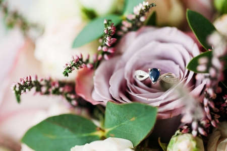 Sapphire white gold engagement ring background. Pink rose flowers wedding bouquet background....