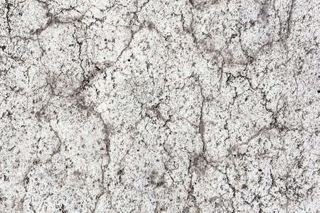 White paint asphalt cracks texture. Scratched lines background. White and black distressed grunge...