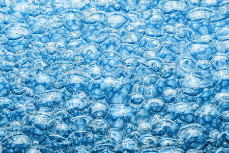 Blue foam background. Soap bubble structure. Closeup washing suds texture. Bright bubbles pattern.