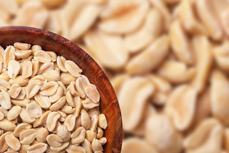 Peanuts in wooden bowl isolated. No shell nuts texture. Peeled peanuts background.