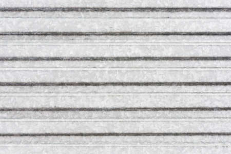 Corrugated metal sheet background. Grunge old grainy metal texture. Silver color industrial pattern. Garage construction gray striped wall.の写真素材