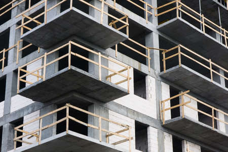 Luxurious apartments for sale. Bricks and concrete. Construction site background. High block of...