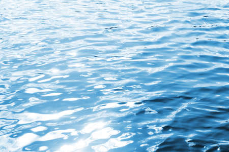 Ripples on lake water. Sunlight reflecting in water. Sun shining by the lake. Ocean wave background....