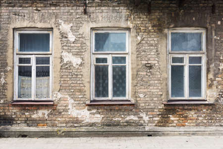 Old ruined building window. Brick wall apartment building background. Post war architecture. Broken...