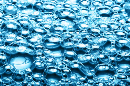Water foam texture. Blue bubble spa background. Foam structure backdrop. Shapoo soap washing pattern. Shiny air bubbles. Closeup washing suds. Detergent, water and oil reaction.の写真素材