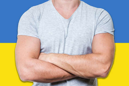 A man in a gray t-shirt on the background of the flag of Ukraineの写真素材
