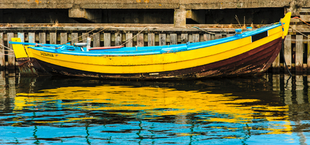 old yellow boat moored in the portの写真素材