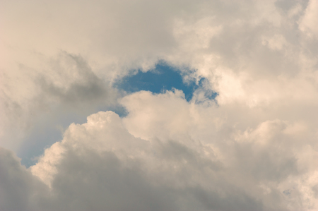 blue sky seen through a hole in the cloudsの写真素材