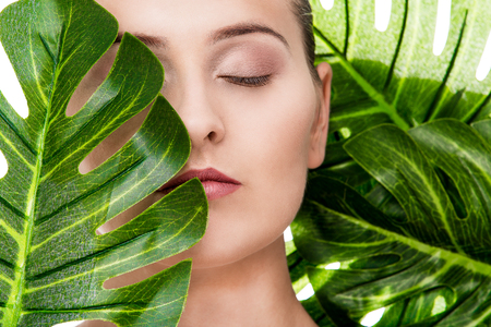 Woman beauty portrait with tropical leafの写真素材