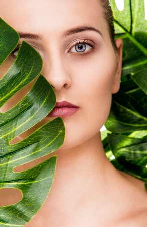 Woman beauty portrait with tropical leafの写真素材
