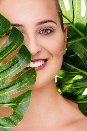 Woman beauty portrait with tropical leafの写真素材