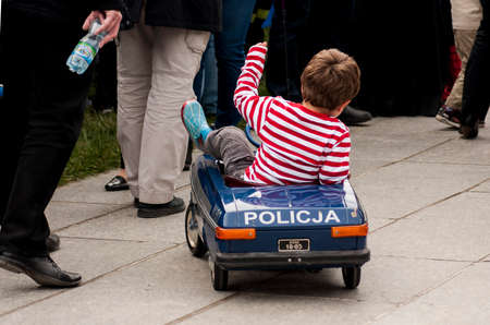 SZCZECIN, POLAND - MAY 29, 2014  Veterans Day in Poland Young boy driving police toy car on sidewalk のeditorial素材