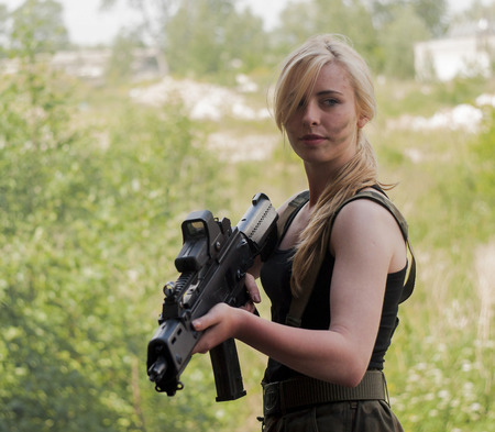SZCZECIN, POLAND - MAY 31, 2014: Beautiful sexy blond woman holding army weapon, during historical reconstructionのeditorial素材