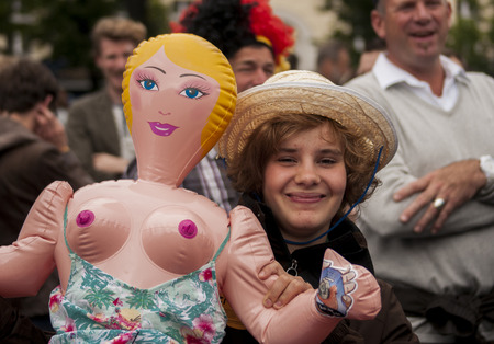 BERLIN, GERMANY - JUNE 21, 2014: Christopher Street Day. Crowd of people Participate in the parade celebrates gays, lesbians, bisexuals and transgenders. Prominent in the image, Smiling Woman with blow up dollのeditorial素材