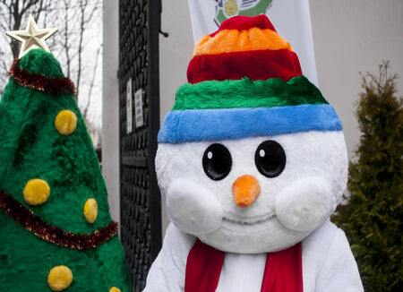 SZCZECIN, POLAND -  DECEMBER 6, 2014: Funny snowman and green Christmas treeのeditorial素材