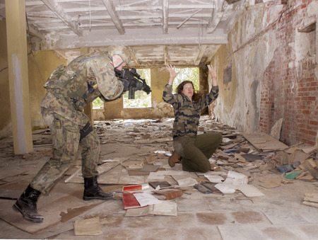 SZCZECIN, POLAND - MAY 31, 2014: Female hostage and soldier with gun, during historical...