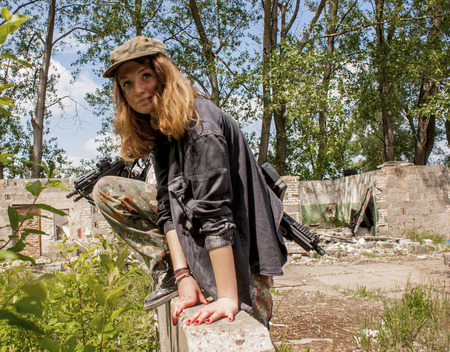 SZCZECIN, POLAND - MAY 31, 2014: Beautiful sexy woman with machine gun, jumping over wall during Historical reenactment.のeditorial素材