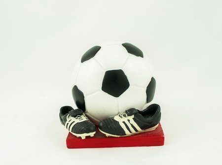 Money box as the ball and shoes on a white backgroundの写真素材