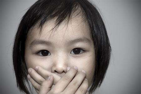 little girl covering her mouth, crime witness concept.の写真素材