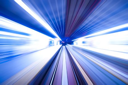 Fast train passing by train station at dusk. Long exposure. Focus on the road.の写真素材