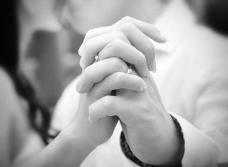 A bride and groom kissing on their wedding day, focus on hands の写真素材