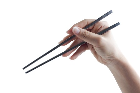Hand holding a pair of chopsticks, isolated on white background.の写真素材