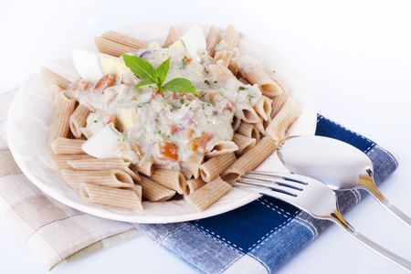Carbonara pasta with egg, tomato, and basil leafの写真素材