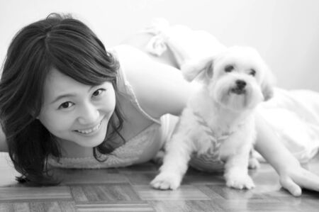 Asian woman playing with her pet, black and white.の写真素材